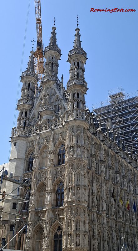Leuven Town Hall's ornate Gothic facade under restoration scaffolding