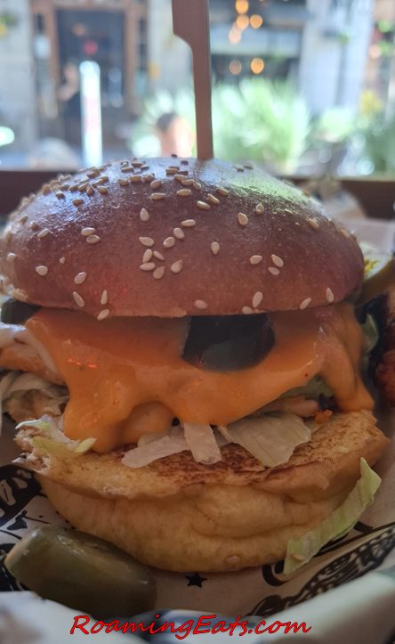 A close-up of a Manhattn's burger with melted cheddar